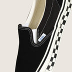 LX Classic Slip-On 98 (CHCKRBRD SIDEWALL BLACK/MARSHMALLOW) #Black/White [VN000E96BPQ]